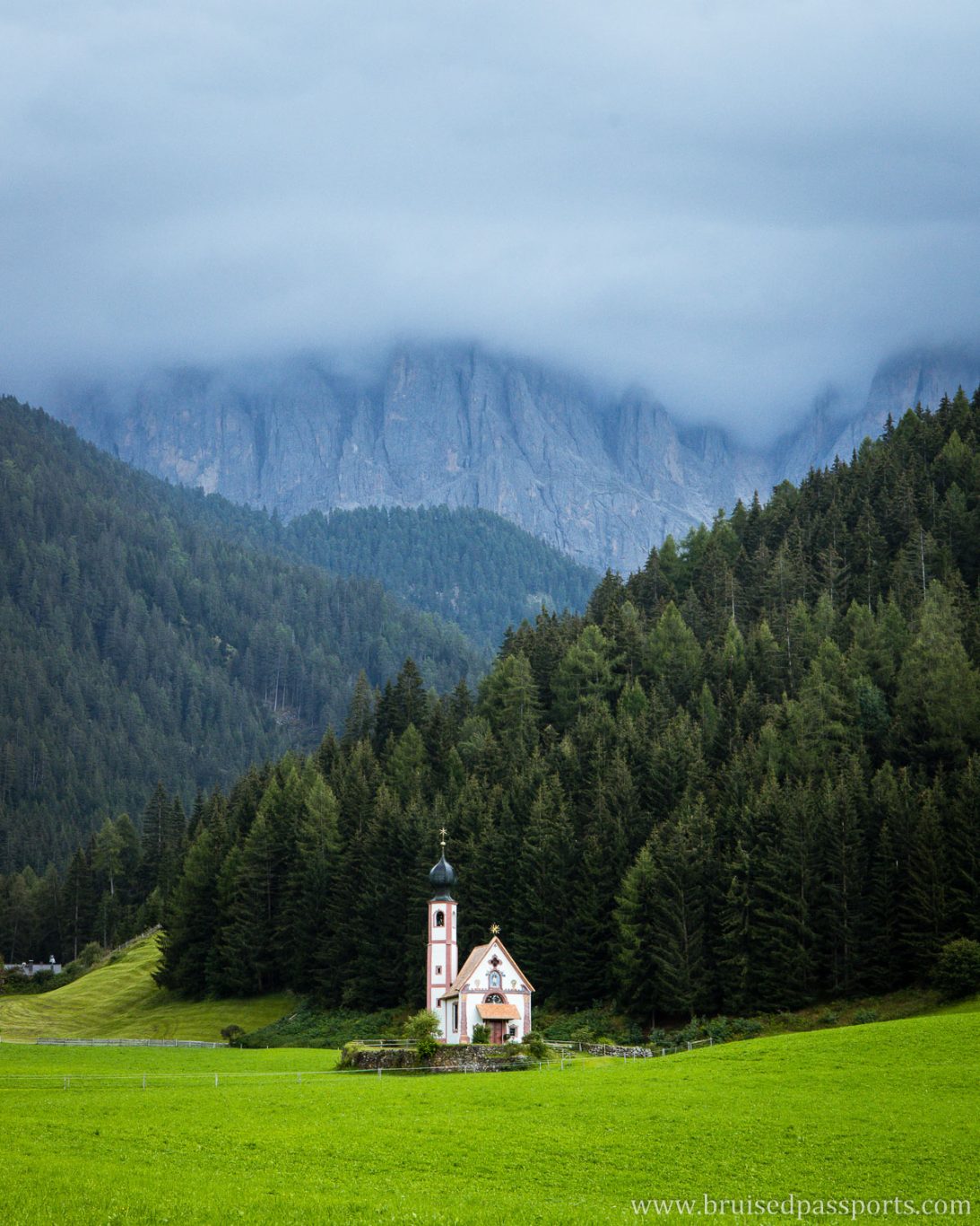 small church of Ranui in Dolomites surrounded by clouds