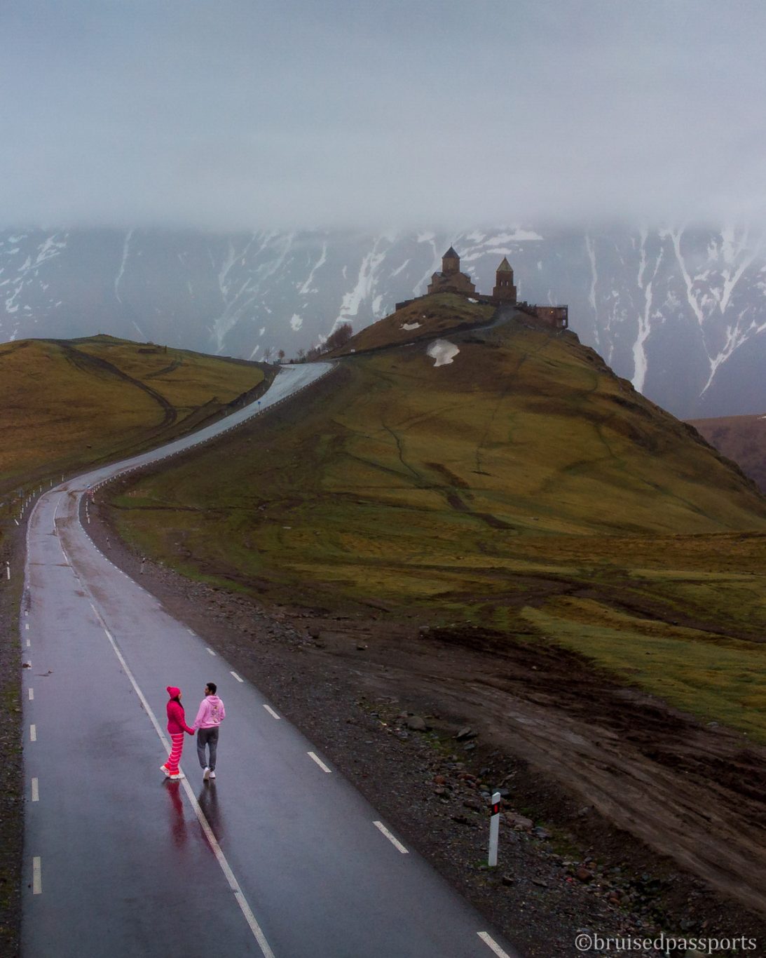 Couple at Gergeti Trnity Church in Kazbegi after thunderstorm