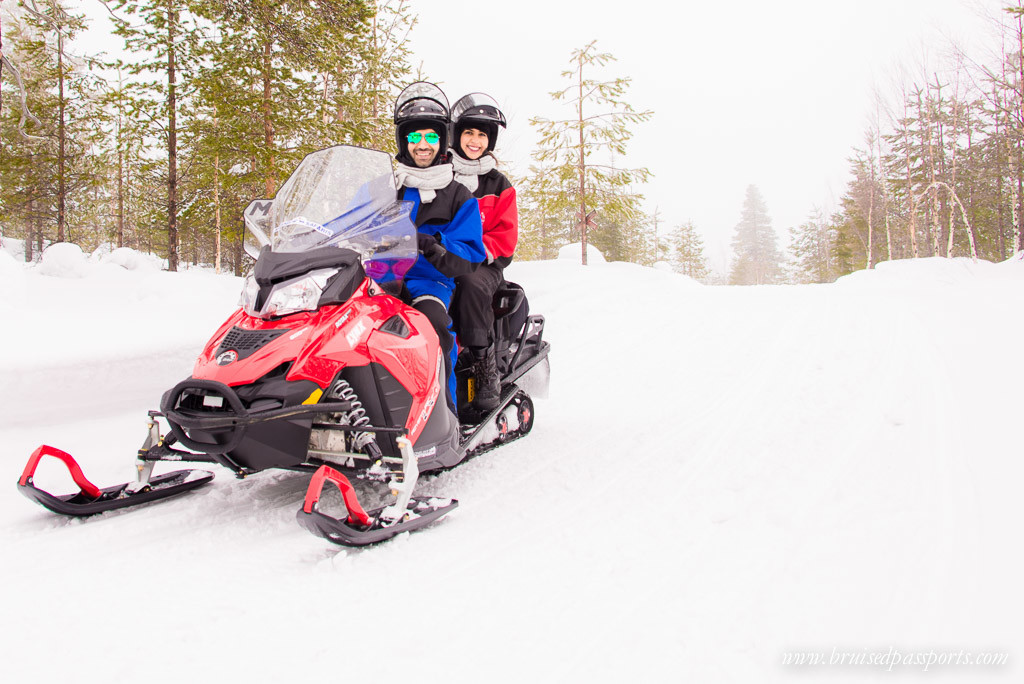 Us on our snowmobile driving into the Arctic forest in Rovaniemi