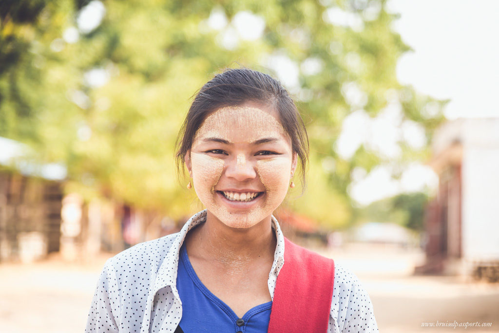 Myanmar smiling girl with thanaka paste on her face 