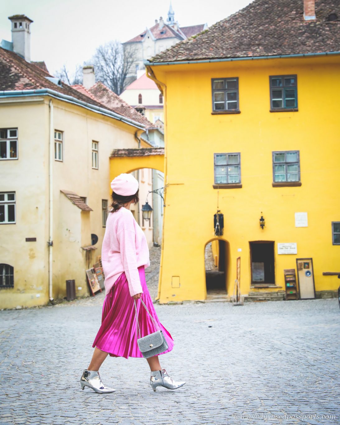 girl walking in front of coloured houses in Romania