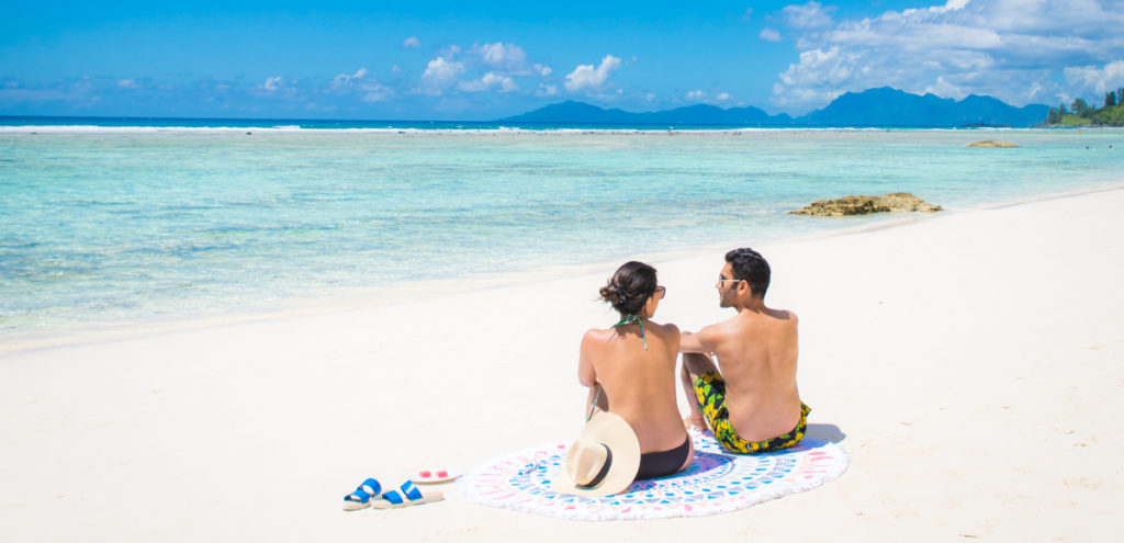 Couple sunbathing on beach at Silhouette Island