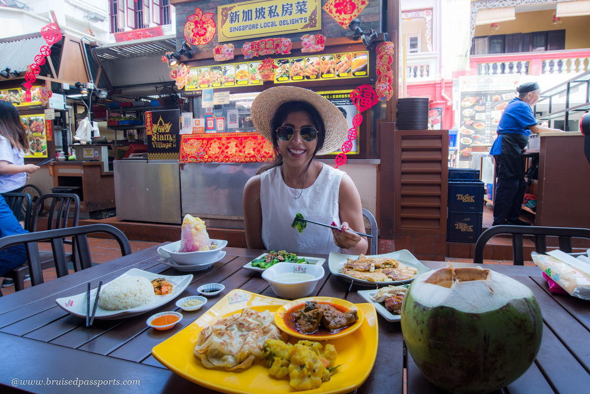 girl trying local cuisine at a hawker centre in Singapore