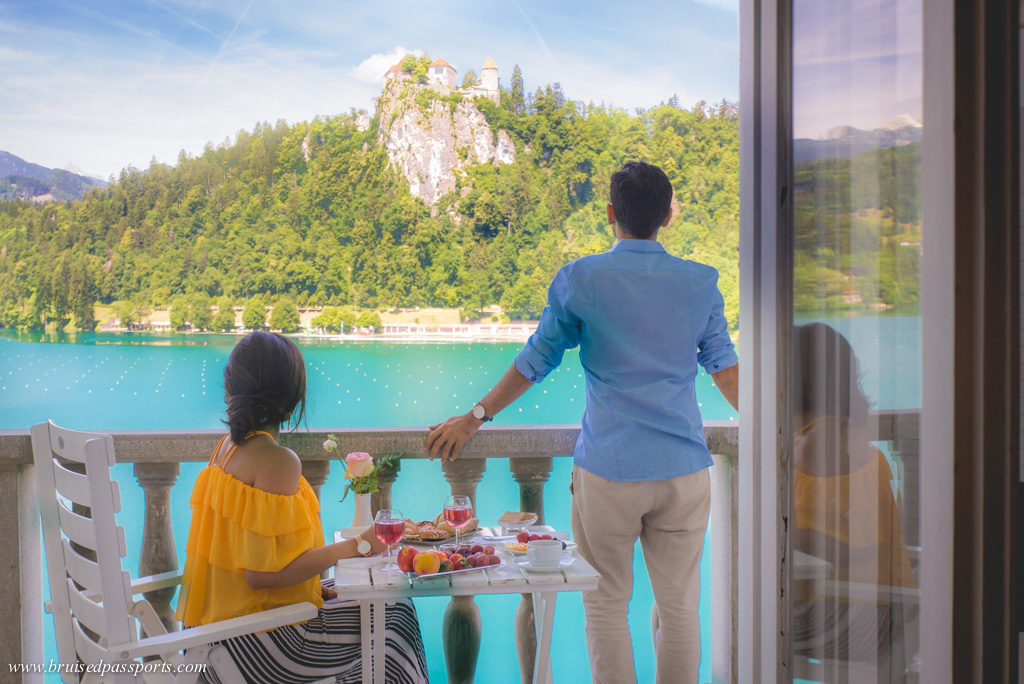 Couple enjoying breakfast on the balcony of Grand Hotel Toplice overlooking Bled Castle