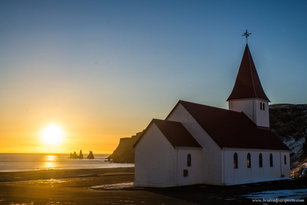 church of vik at sunset with the rocks at the back